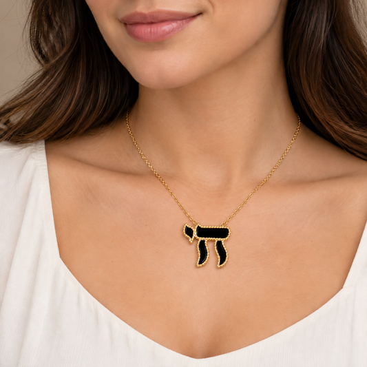 Collier Haï grand modèle doré noir porté au cou d’une femme